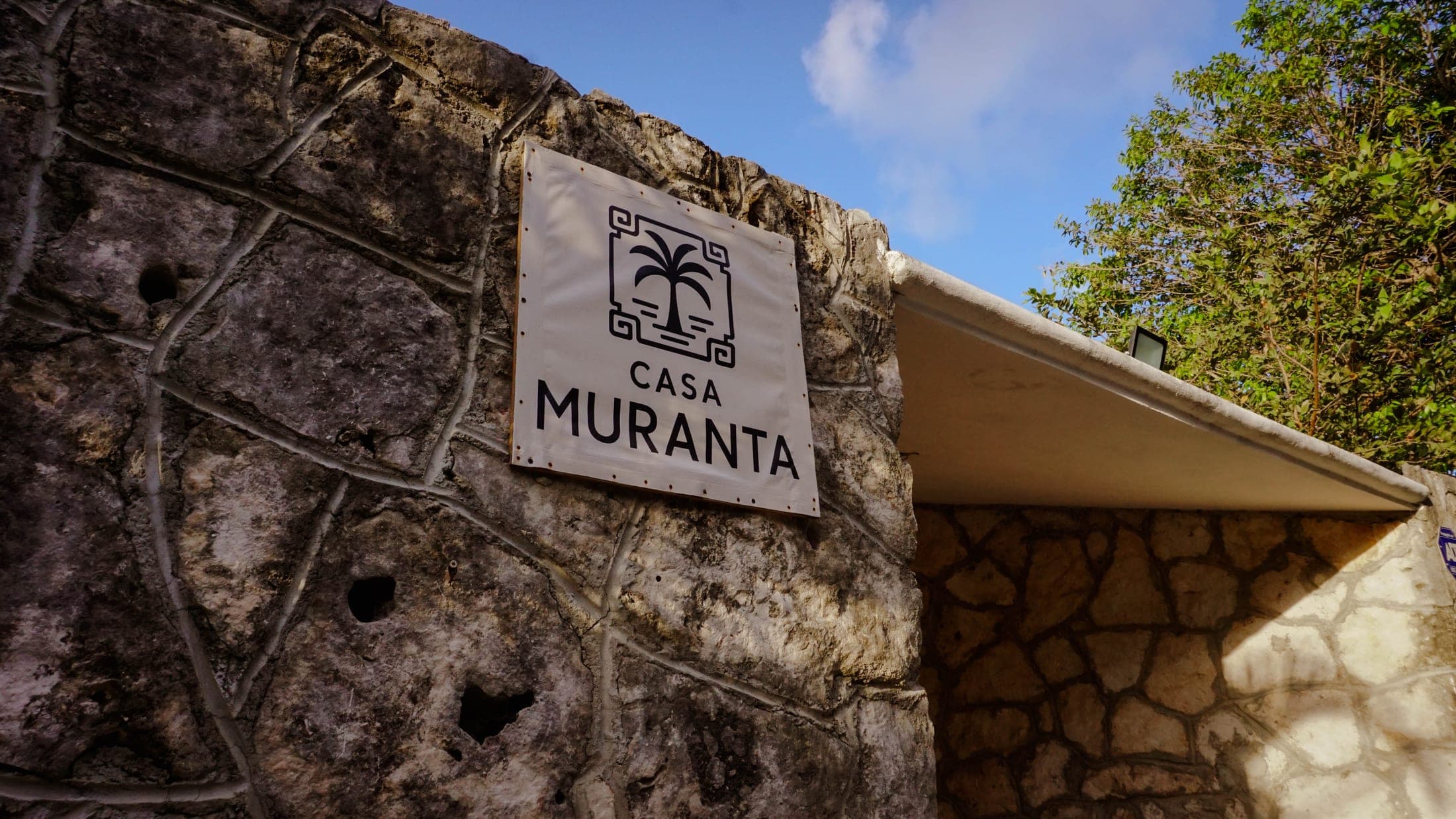 Stone entrance with the Casa Muranta logo